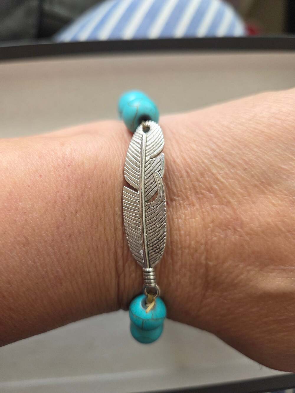 Faux-turquoise stretch bracet beads with a silver-tone metal feather charm